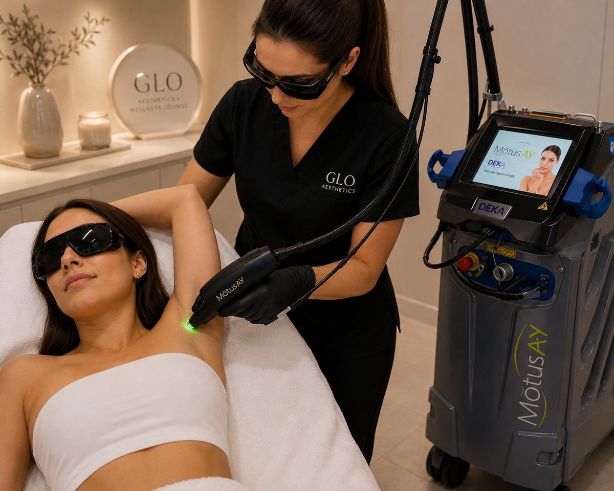 Esthetician performing laser treatment on clients shoulder wearing protective eyewear in modern spa setting
