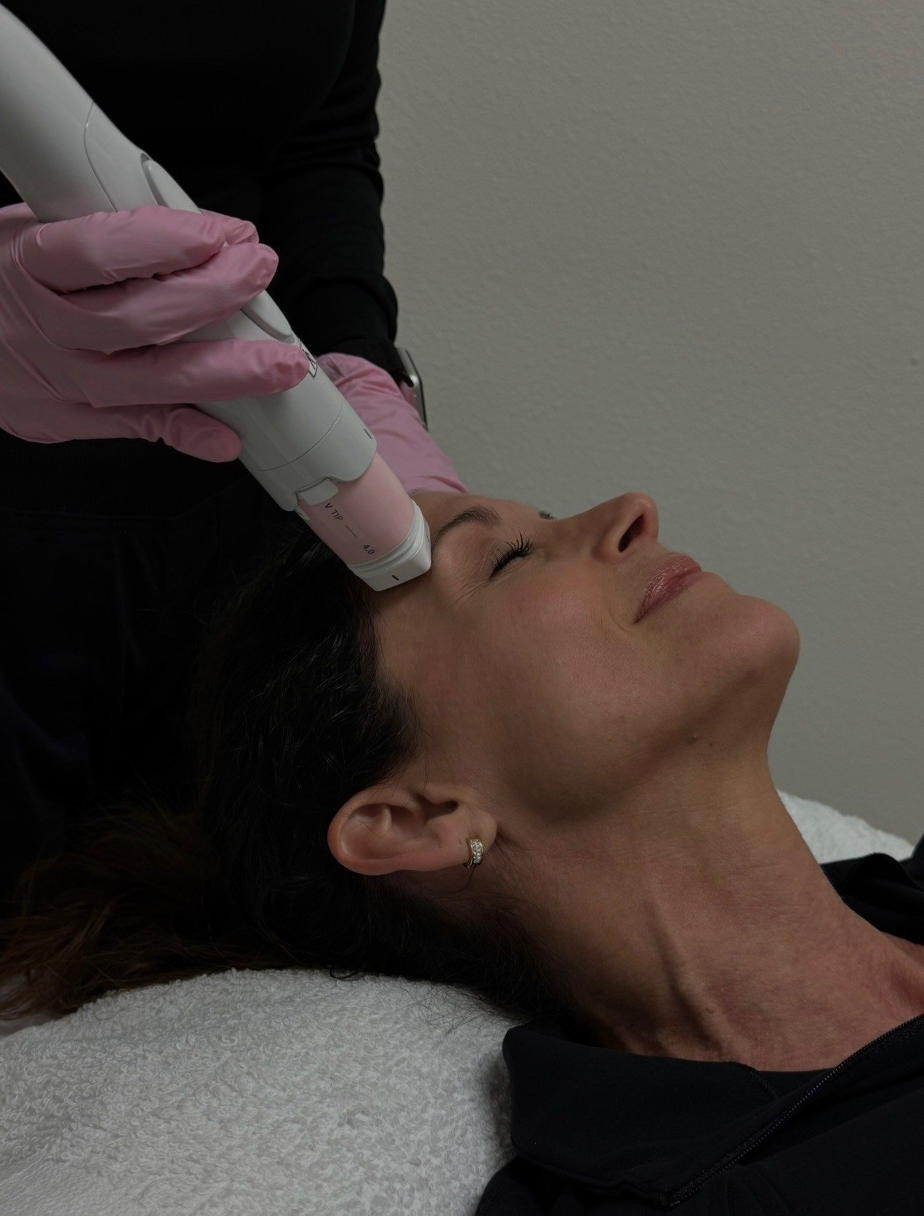 Professional facial treatment being performed with a handheld ultrasound device